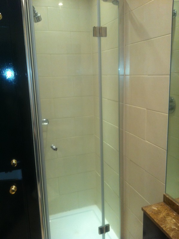 Frameless glass shower enclosure with chrome fittings in Soho