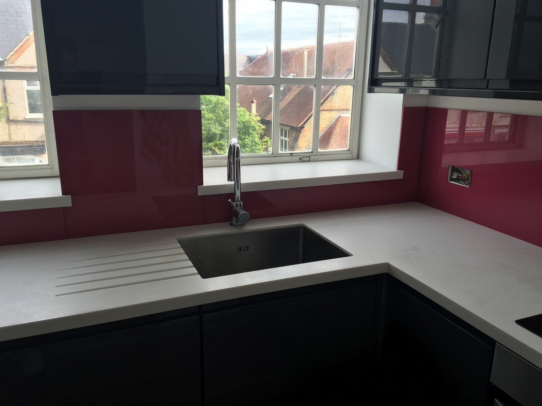 Deep plum coloured glass splashback in modern Soho kitchen